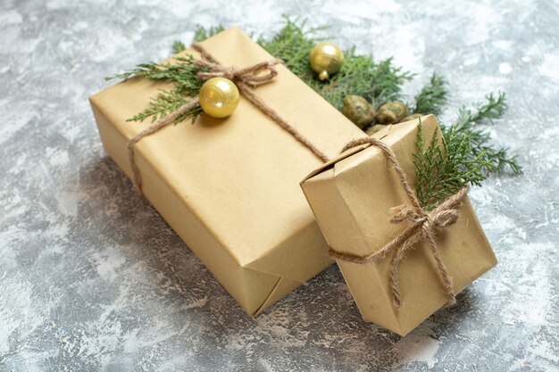 Vue de face des cadeaux de Noël avec une branche verte sur fond blanc