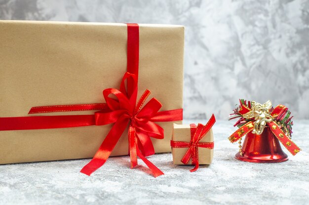 Vue de face des cadeaux de Noël emballés avec un arc rouge sur fond blanc