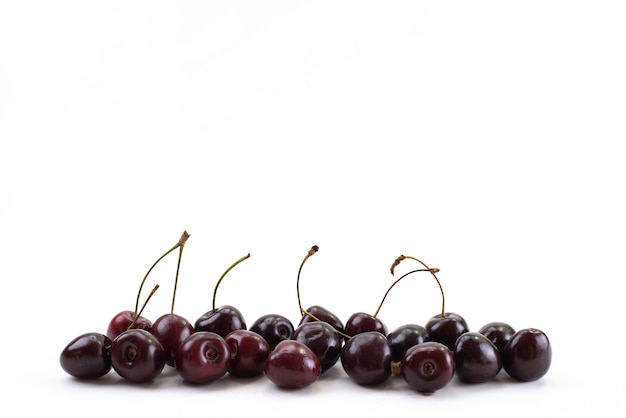 Une vue de face de cerises rouges fraîches moelleuses et juteuses sur blanc, mûres moelleuses