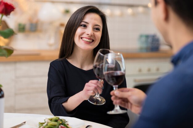 Vue de face charmant couple acclamant avec des verres de vin