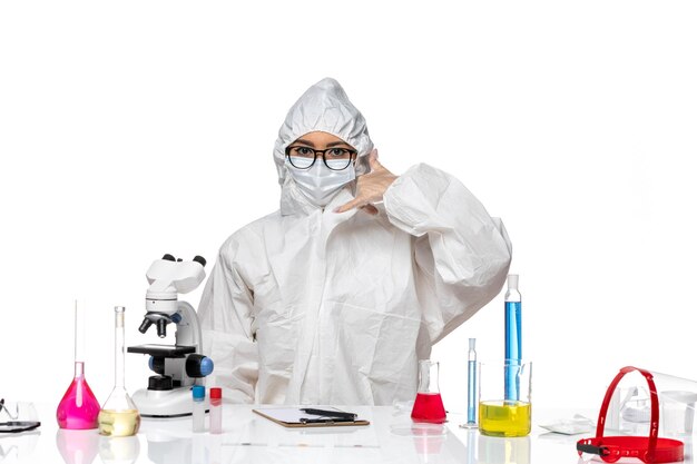 Vue de face chimiste en combinaison de protection spéciale travaillant posant sur le sol blanc covid- laboratoire de virus de chimie
