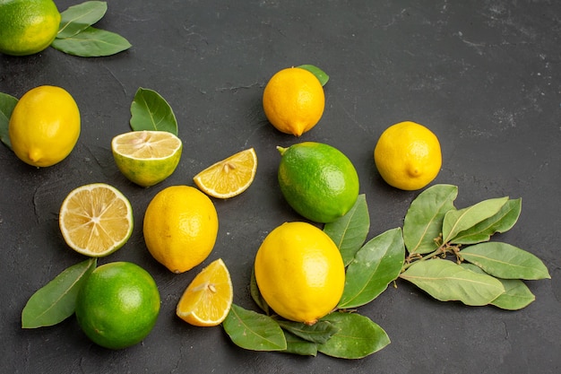 Vue de face de citrons frais fruits aigres sur le fond sombre