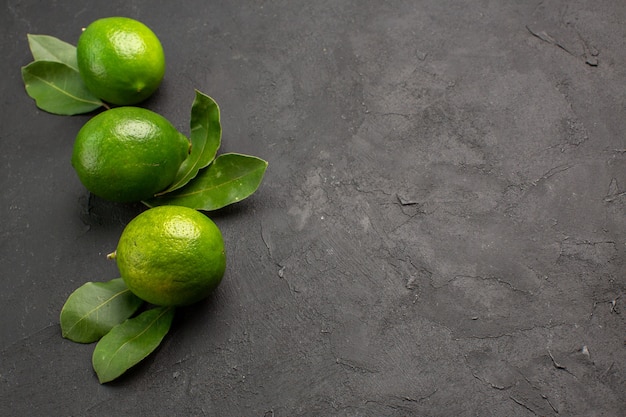 Vue de face citrons verts frais sur fond sombre