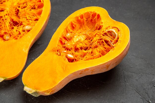 Vue de face de citrouilles fraîches tranchées sur table sombre