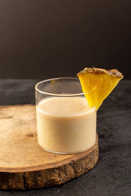 Une vue de face cocktail délicieux boisson rafraîchissante à l'intérieur du petit verre près d'un bureau en bois sur le fond sombre boire du jus d'été