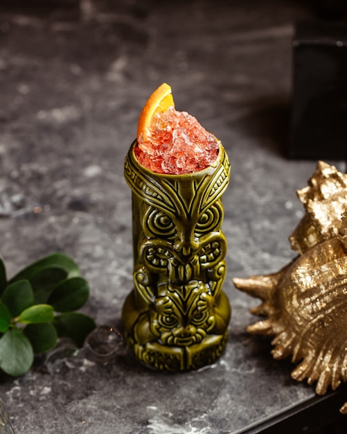 Une vue de face cocktail frais à l'intérieur du verre souvenir sur la surface sombre avec jus de fruits de boisson