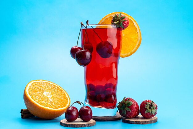 Une vue de face cocktail de fruits frais avec des tranches de fruits frais refroidissement par glace sur bleu, boisson jus de fruits cocktail couleur de fruits