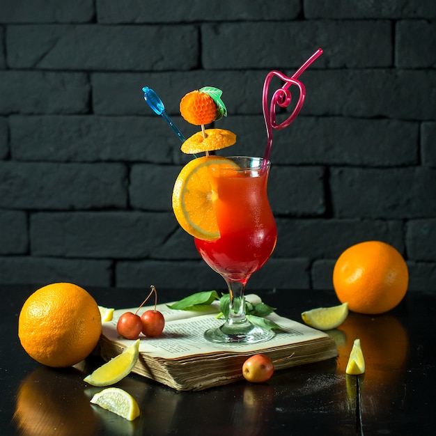 Vue de face cocktail onn livre ouvert avec une tranche d'orange sous la forme d'un décor
