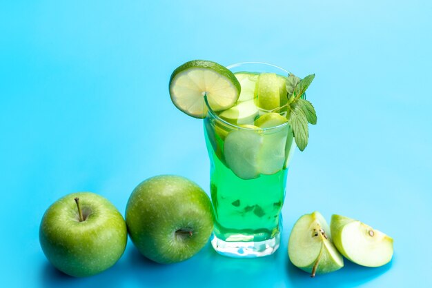 Une vue de face cocktail de pomme fraîche et rafraîchissante avec des pommes fraîches et des tranches de citron sur bleu, jus de fruits frais