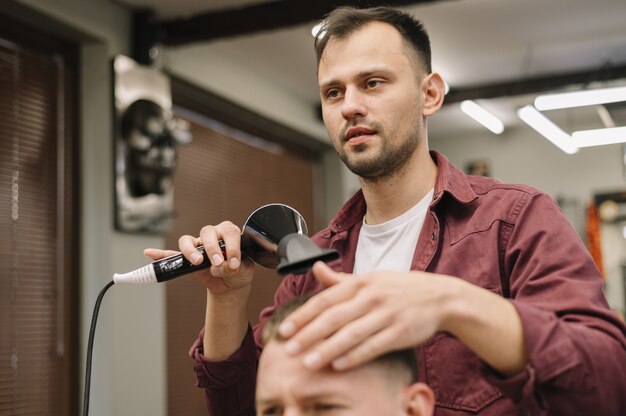 Vue de face de la coiffure à l'aide du sèche-cheveux