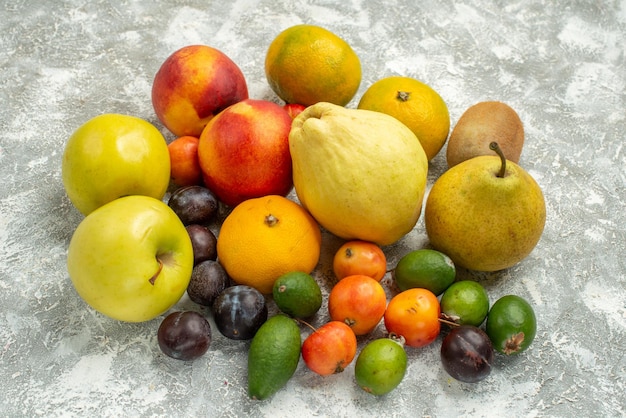 Vue de face composition de fruits différents fruits frais sur espace blanc