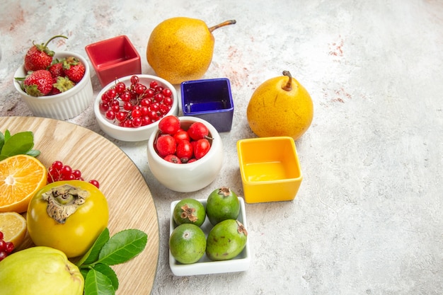 Vue de face composition de fruits différents fruits sur table blanche baies couleur mûre fraîche