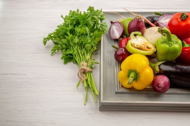 Vue de face composition végétale avec assaisonnements et légumes verts sur fond blanc photo couleur légume vie saine salade repas mûr