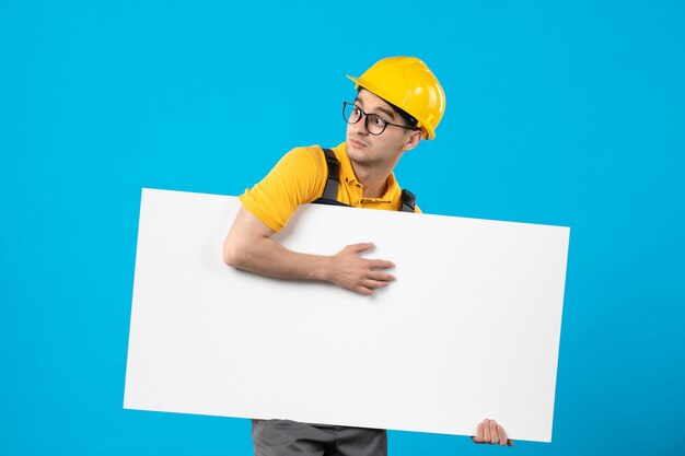 Vue de face constructeur masculin en uniforme jaune avec plan sur bleu