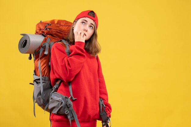 Vue de face cool femme voyageur avec sac à dos penser à quelque chose