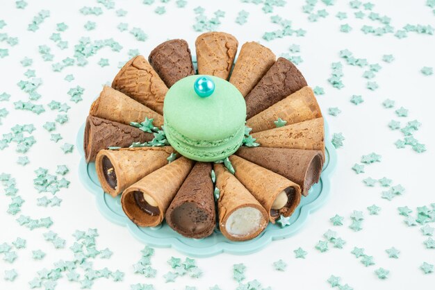 Une vue de face cornes de glace avec macaron français vert sur blanc, dessert biscuit gâteau