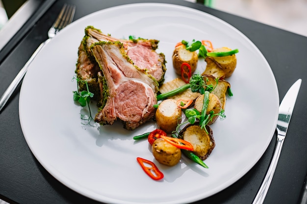 Vue de face côtes levées avec pommes de terre et herbes