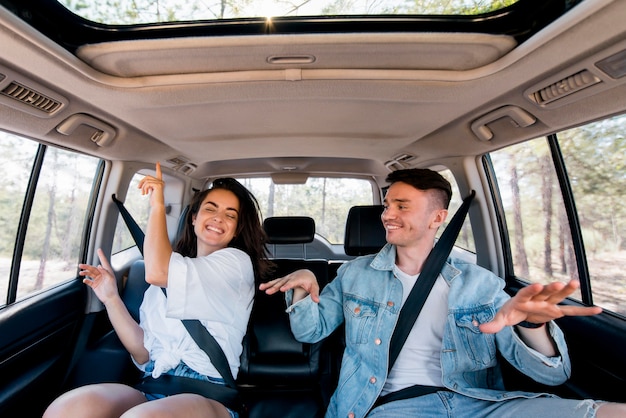 Vue de face couple danse à l'intérieur de la voiture