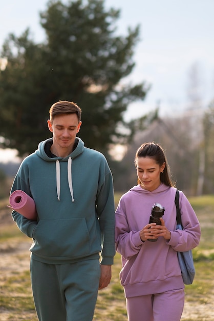 Photo gratuite vue de face couple marchant à l'extérieur