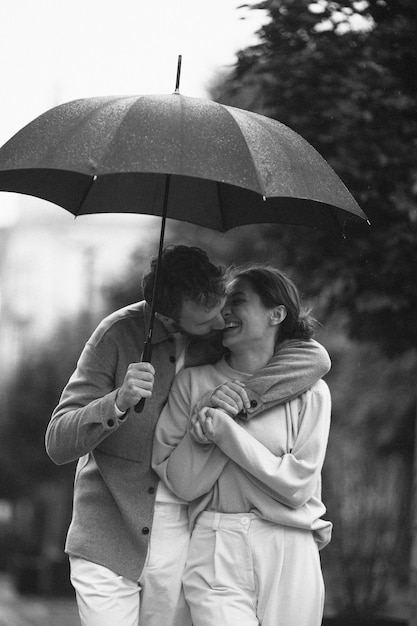 Photo gratuite vue de face couple marchant avec parapluie