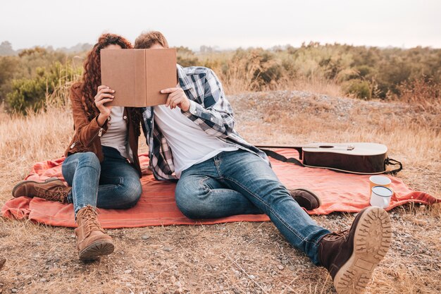 Vue de face, couple, regarder, livre