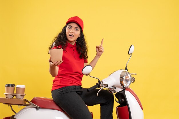 Vue de face coursier féminin à vélo pour la livraison de café et de nourriture sur le fond jaune service livraison uniforme travailleur travail travail femme