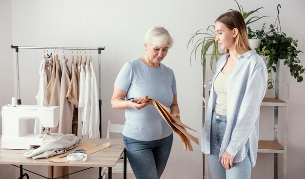 Vue de face de la couturière dans le studio avec le client