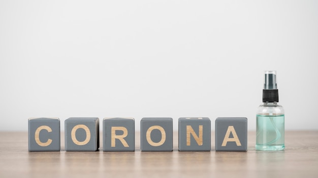 Vue de face des cubes en bois avec corona et désinfectant pour les mains