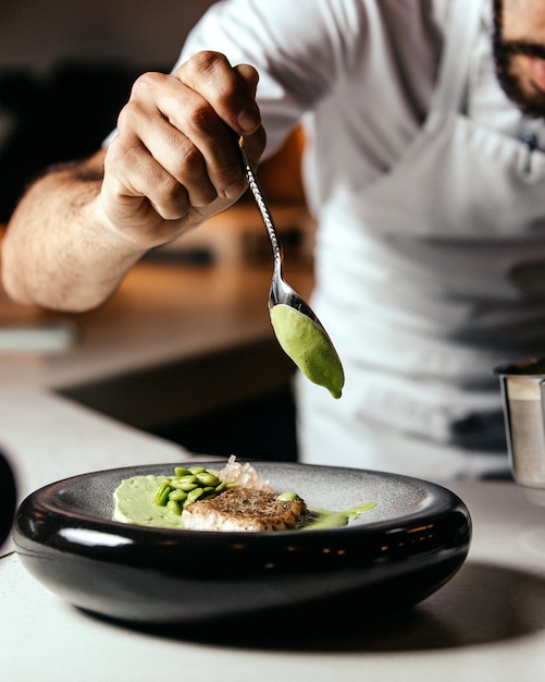 Une vue de face cuisinier préparer la nourriture à l'intérieur de la cuisine alimentaire repas fry cook