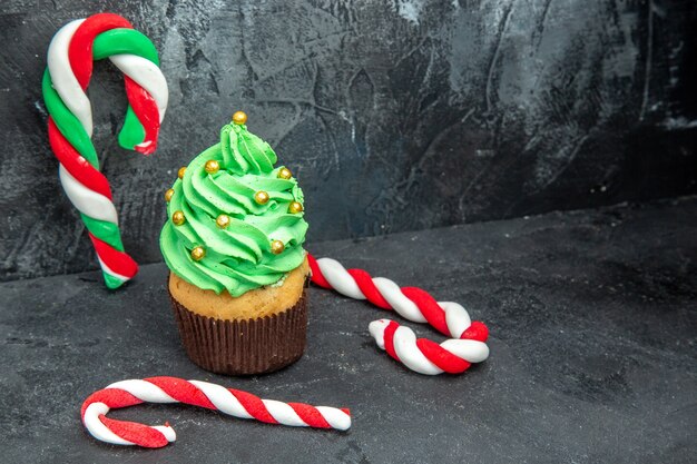 Photo gratuite vue de face cupcake sapin de noël et bonbons de noël sur un endroit sombre et libre