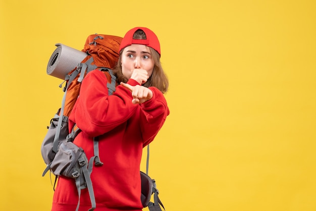 Vue de face curieux voyageur femme en sac à dos rouge en regardant quelque chose