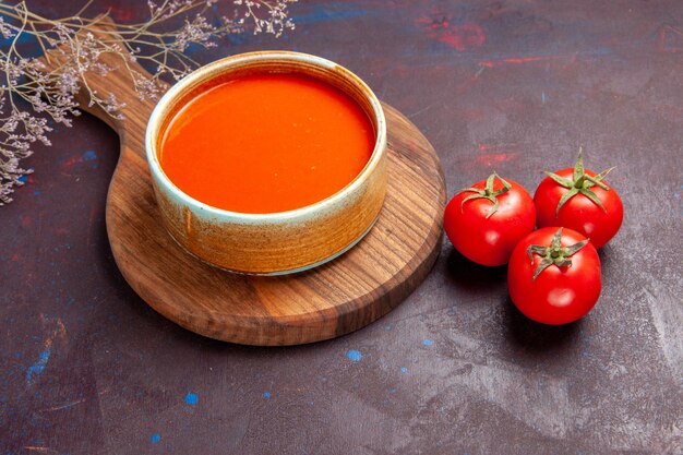 Vue de face délicieuse soupe aux tomates avec des tomates fraîches sur un espace sombre