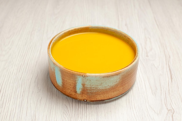 Photo gratuite vue de face délicieuse soupe à la crème soupe de couleur jaune sur un bureau blanc soupe sauce repas plat à la crème dîner