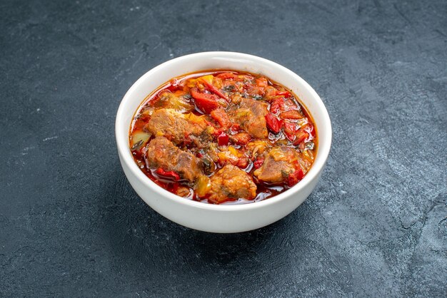 Vue de face délicieuse soupe de légumes avec de la viande à l'intérieur de la plaque sur l'espace gris