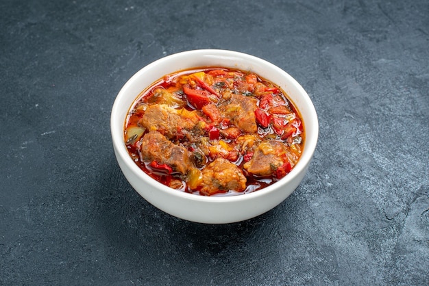 Vue de face délicieuse soupe de légumes avec de la viande à l'intérieur de la plaque sur l'espace gris