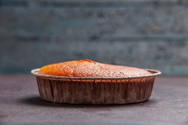 Vue de face délicieuse tarte ronde douce cuire au four sur le fond sombre pâte à biscuits gâteau à tarte sucre thé sucré