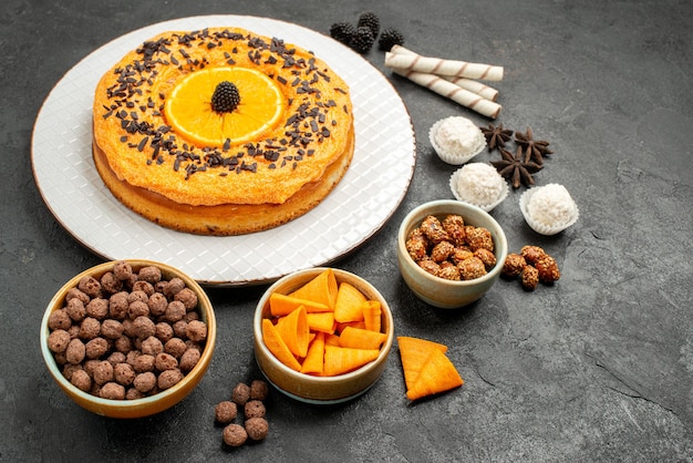 Vue de face délicieuse tarte sucrée avec des tranches d'orange sur fond gris foncé pâte gâteau tarte aux fruits biscuit