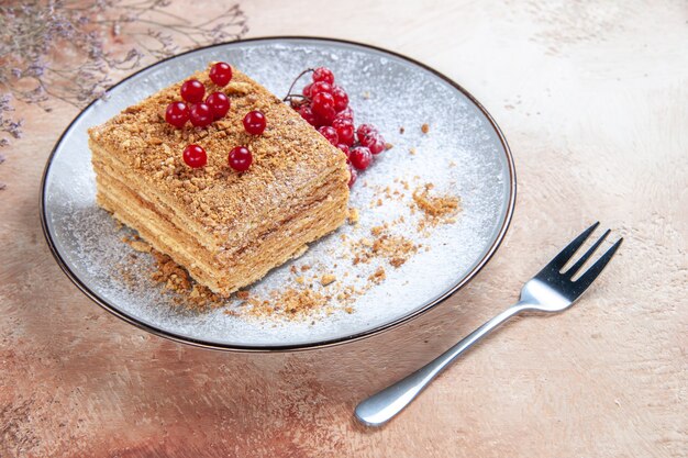 Vue de face délicieuse tranche de gâteau aux fruits rouges à la lumière