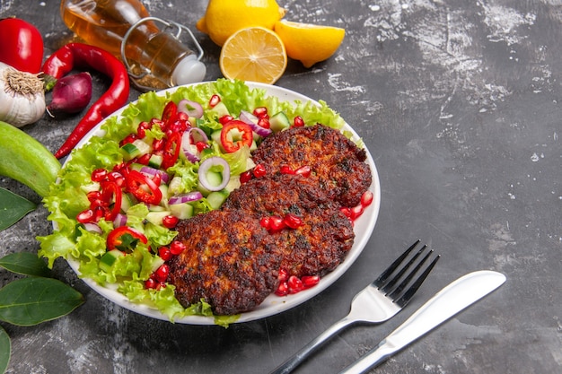 Vue de face de délicieuses côtelettes de viande avec salade fraîche