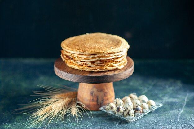 Vue de face de délicieuses crêpes sur un bureau en bois et un petit-déjeuner sombre tarte au gâteau au lait sucré thé du matin