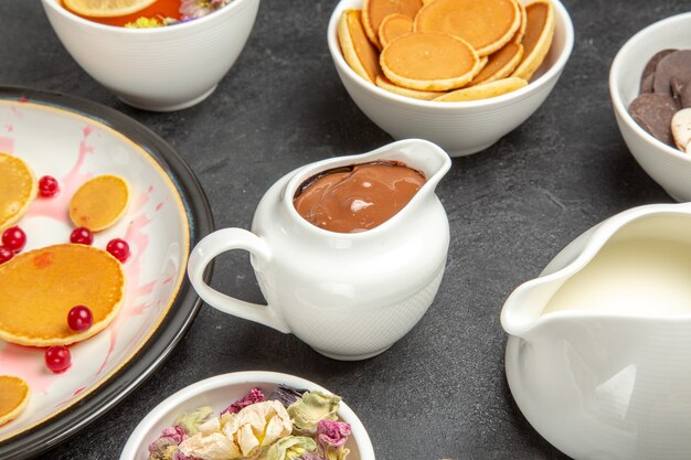 Vue de face de délicieuses crêpes avec des cookies dans l'obscurité