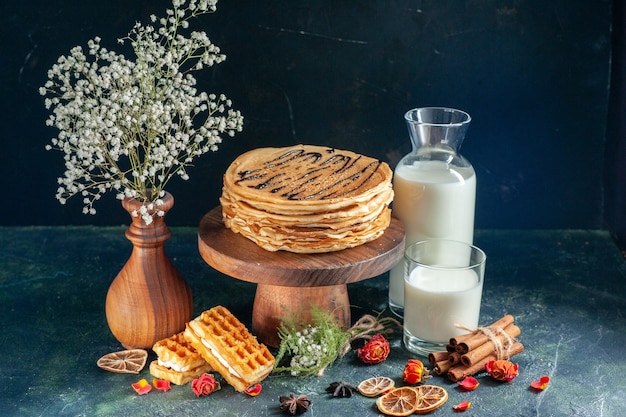 Vue de face de délicieuses crêpes sur une surface bleu foncé