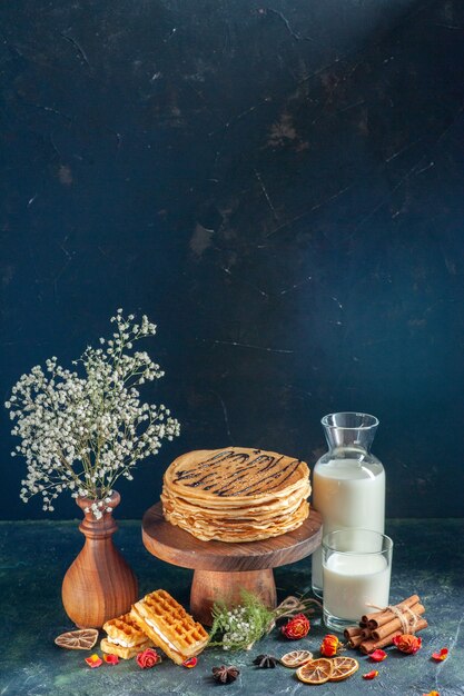 Vue de face de délicieuses crêpes sur une surface bleu foncé