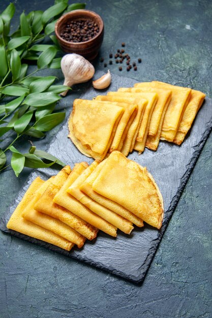 Vue de face de délicieuses crêpes sur une surface bleue