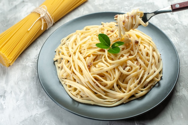 Vue de face de délicieuses pâtes italiennes sur un plat de couleur claire