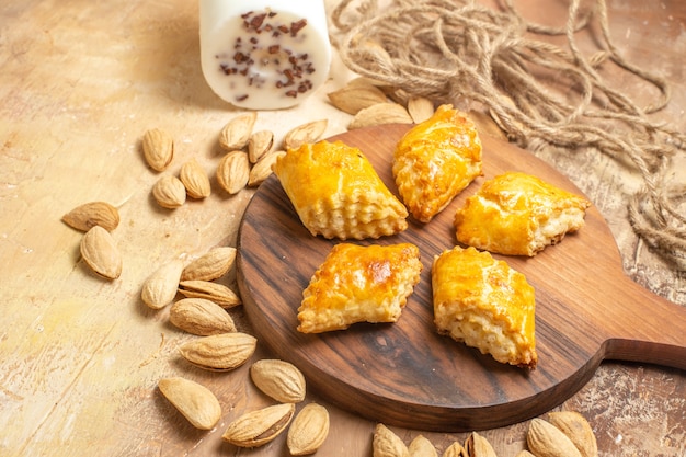 Vue de face de délicieuses pâtisseries aux noix avec des noix sur une surface en bois