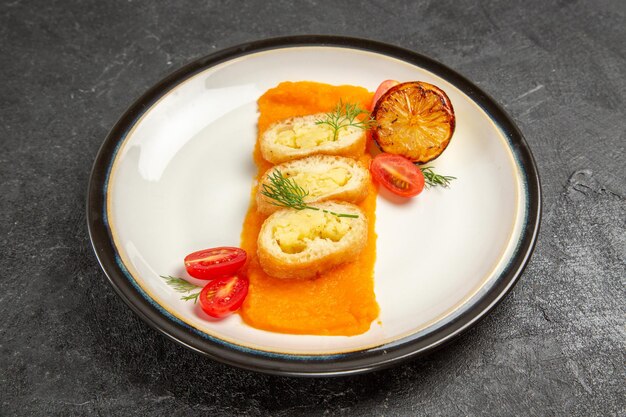 Vue de face de délicieuses tartes aux pommes de terre avec de la citrouille à l'intérieur de la plaque sur le fond gris foncé cuire au four la tranche de dîner