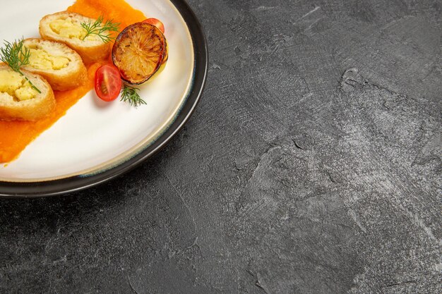 Vue de face de délicieuses tartes aux pommes de terre avec citrouille à l'intérieur de la plaque sur fond gris foncé plat de cuisson au four tranche de dîner