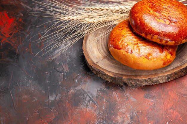 Vue de face de délicieuses tartes pour le thé sur la tarte au gâteau de table sombre pâtisserie douce