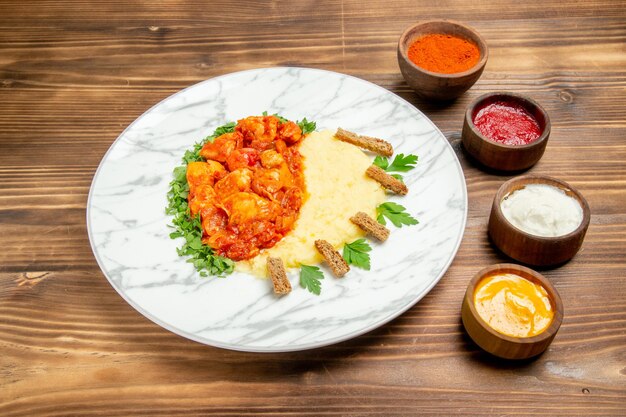 Vue de face de délicieuses tranches de viande avec purée de pommes de terre et assaisonnements sur un plat de bureau en bois repas de viande pomme de terre pain alimentaire